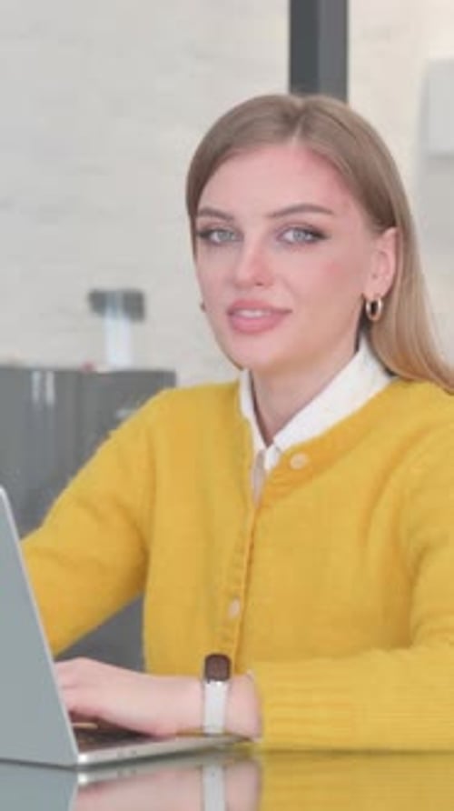 Smiling Woman Works on Laptop at Desk