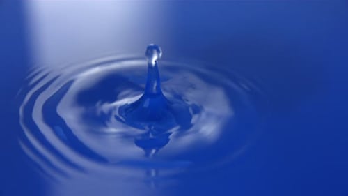 Water Droplet Ripples In Pool of Blue Water