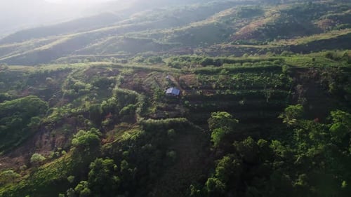 Cinematic Drone Orbit Around Small Hut on Green Hillside at Sunrise