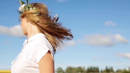 Woman Wearing Flower Crown Touches Hair in Field