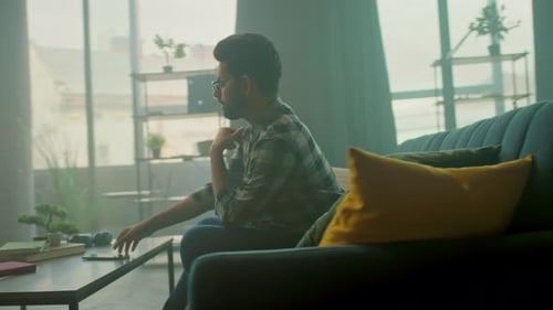 Young Adult Using Smartphone on Couch at Home