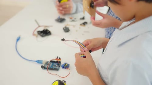 Close up of Asian kid boy student learning about robotics in school.