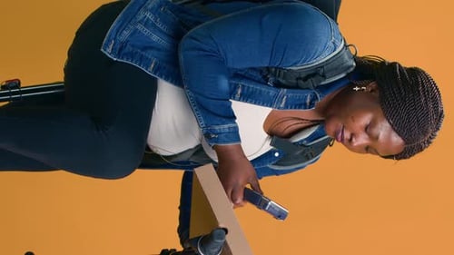 Woman Uses a Device on Orange Background