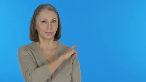 Pointing Old Woman Showing Copyspace on Blue Background