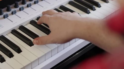 Over The Shoulder View of Male Hands Playing Keyboard Piano Notes During Studio Music Recording Sess