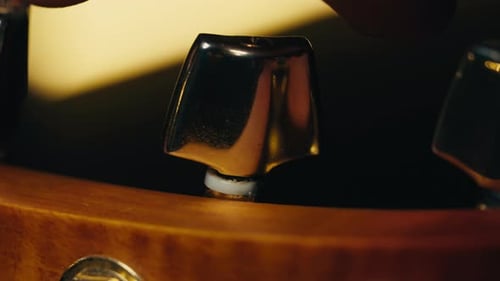 Young Musican Man Checking Strings of Acoustic Guitar Closeup Male Guitarist Tuning Sound of Musical