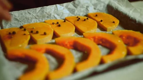 Pour Pepper Corns on Pumpkin Pieces. Close Up Man Hands Pour Pepper