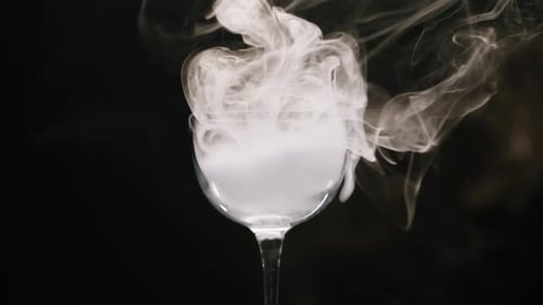 Vidro sobre fundo preto em fumaça, experimento químico, closeup, neblina, fumaça, vapor, textura