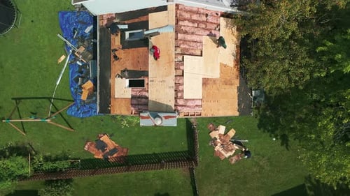 Workers Repairing Roof on House Aerial View