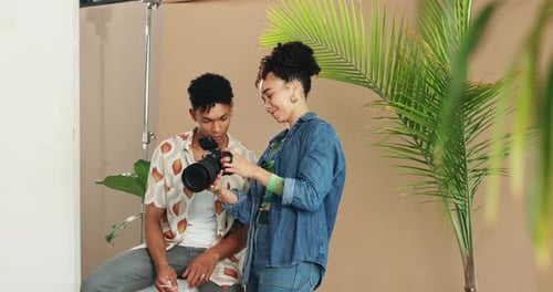 People, model and photographer talking in studio, art and camera to review for direction