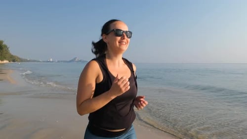 Sporty Woman Running Along Beautiful Sandy Beach