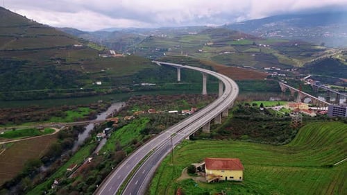 Drone Curved Highway Bridge Rising on Farmland in Hilly Valley Concrete Road