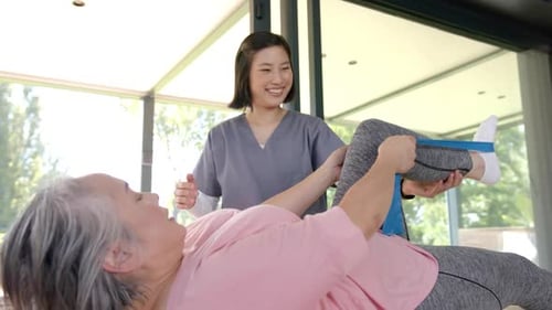 Senior Woman Exercising Leg with Physical Therapist