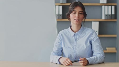Woman Giving Presentation Holding Marker in Office Setting