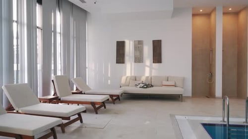 Empty Modern Indoor Pool Lounge with Sunbeds Luxury Leisure Area Large Windows Minimalist Decor in
