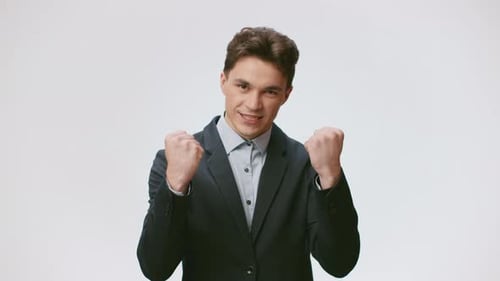Excited Young Man Celebrates with Fists Pumped Smiling