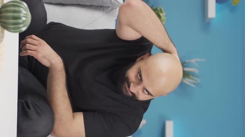 Vertical video of Man looking negative at camera.