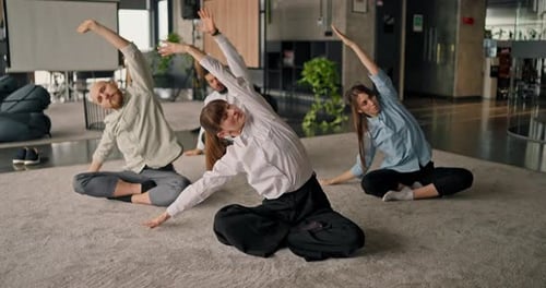 Office Workers Meditate and Stretch Together in Workplace