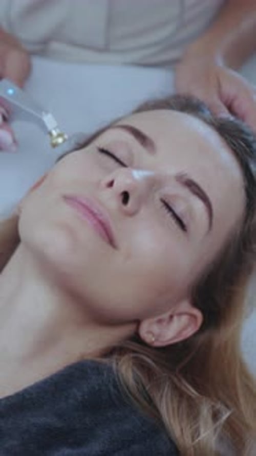 Skilled Esthetician Performs Temple and Eye Lift Closeup of Skin and Precise Wrinkle Reduction