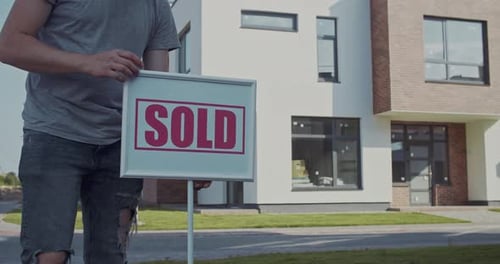 A Property Sold Sign is Displayed Prominently in Front of a Beautifully Modern Home