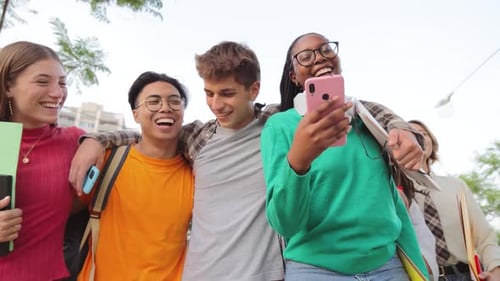 Group of Multiracial Students Walking Together at University Campus and Watching the Social Media on