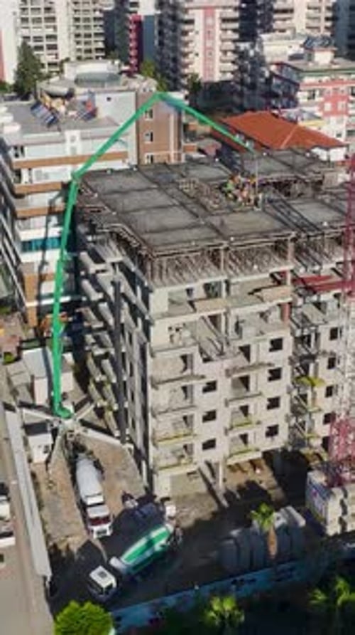 Vertical Video of Residential Construction With Metal Framework Wall Assembly and Concrete Pouring