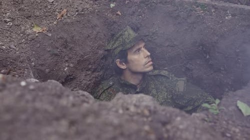 Soldier Lying in a Trench in Camouflage Uniform