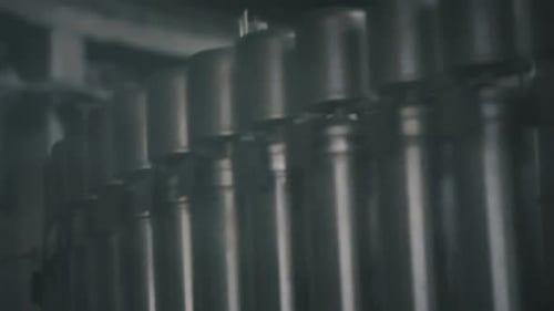 Aluminum cans passing on conveyor belt in beverage factory