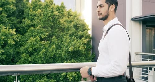 4k video footage of a handsome young businessman checking the rime on his watch in the city
