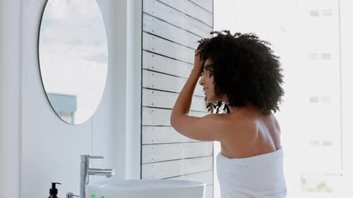 Black woman, afro and hair care in house bathroom for healthcare, wellness