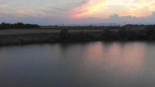 drone view over trees and river at sunset