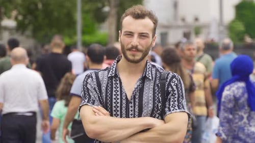 Confident Young Man Smiling in Urban Crowd