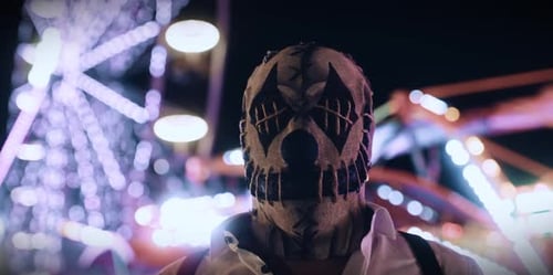 Person Wearing Sinister Mask in Dark at Carnival