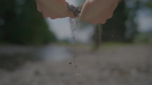 Person Touching and Feeling Stones Rocks Outdoors in Riverbed
