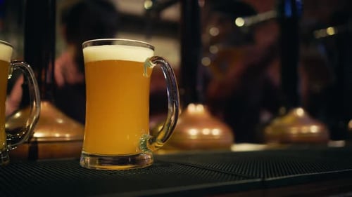 Bubbly Beer Pour Bartender in Closeup Action Filling a Glass with Bubbles