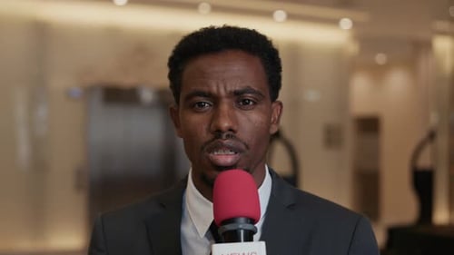 Reportero negro pronunciando una declaración en vivo desde una conferencia política