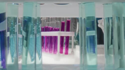Gloved Hand Placing Pink Liquid Test Tube