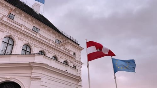 Austrian and EU flags waving in front of building