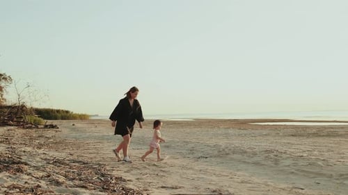 A Loving Mother and Her Excited Child Enjoy a Beautiful Day at the Beach Creating Memories