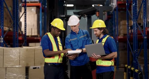 african american male worker discussing shipment checklist with caucasian manager and supervisor in