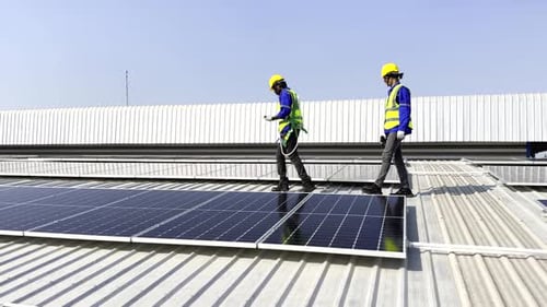 Technician installing solar cell. Installation and maintenance of solar cells on rooftop.