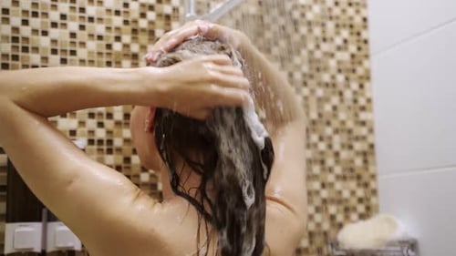 Woman Washing Hair in Shower with Shampoo