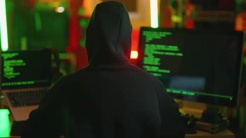 Hacker Writing Code Cracking Computer Man Programmer in Hoodie Cracks System Using Computer in Dark