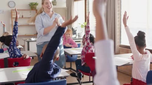 In school, students raising hands in classroom, actively participating in lesson