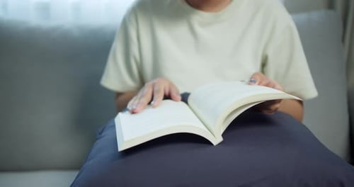 Reading a book at home cozy setting lifestyle content indoor focused viewpoint relaxation