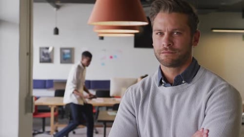 Portrait of happy caucasian businessman looking at camera at office