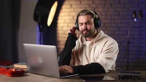 Man Enjoying New Song in Headphones During Work at Studio