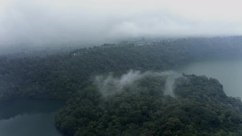 Tropical Forest and Lake Through Clouds