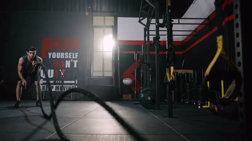 Sport man Workout Exercise with Battle Rope Training Building