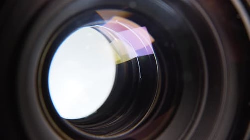Aperture blades opening and closing quickly with white background in a de-clicked lens.